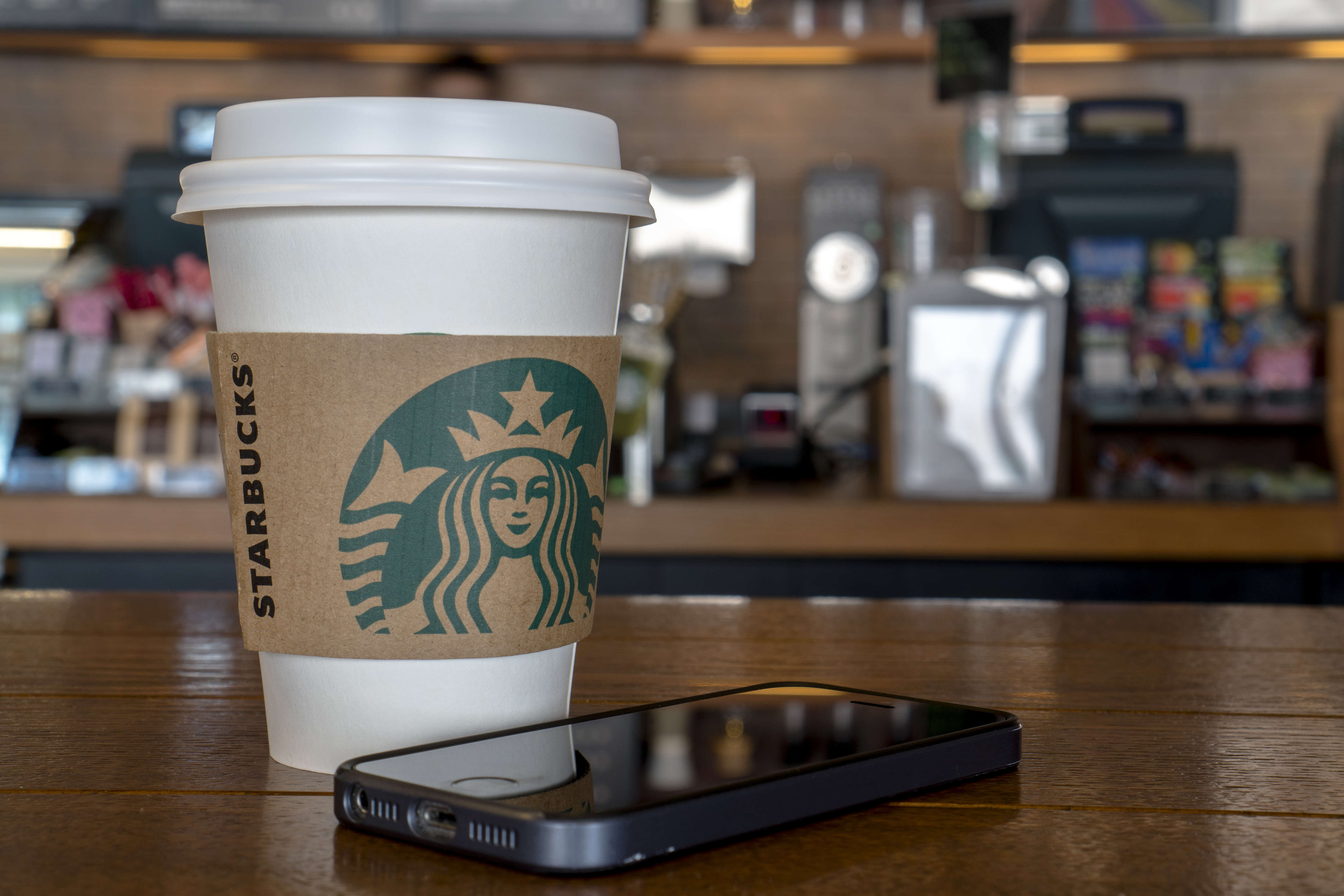 Coffee cup on table in a Starbucks shop. During the third